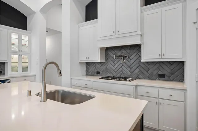 a kitchen with granite countertop white cabinets and window