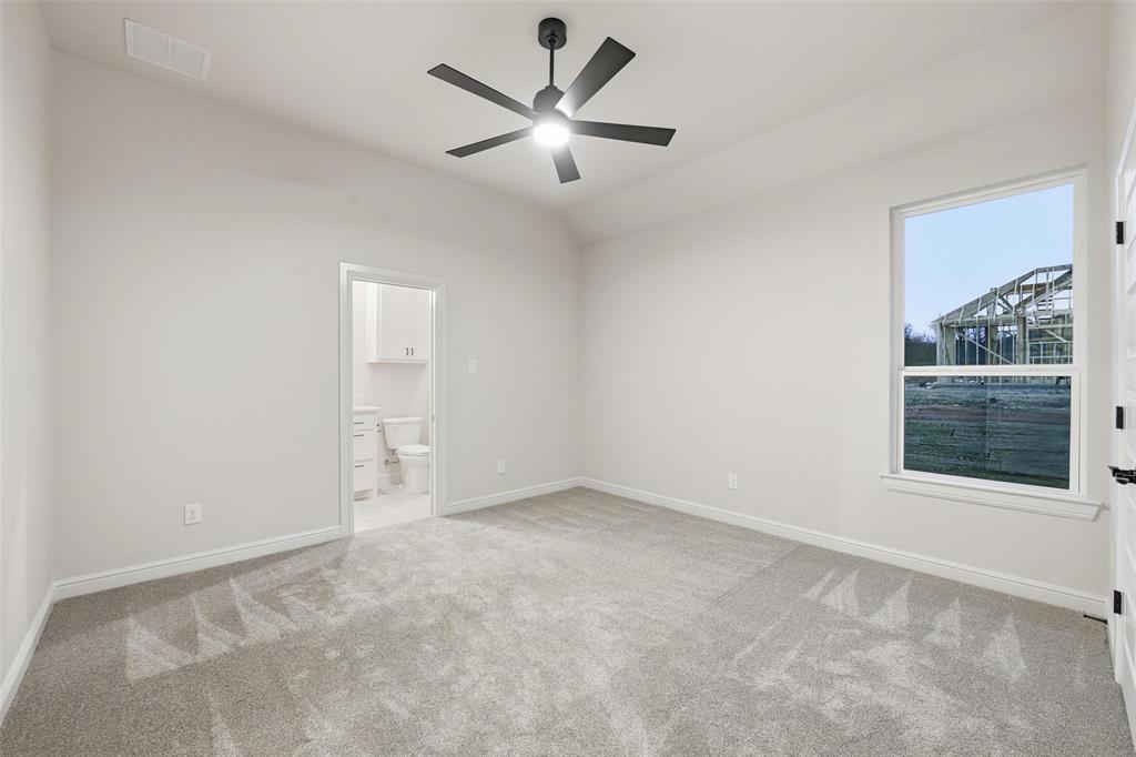 189 Rio Rancho Drive Decatur, TX 76234 - Photo 27 of 36 Unfurnished bedroom featuring light colored carpet, a ceiling fan, ensuite bath, and lofted ceiling