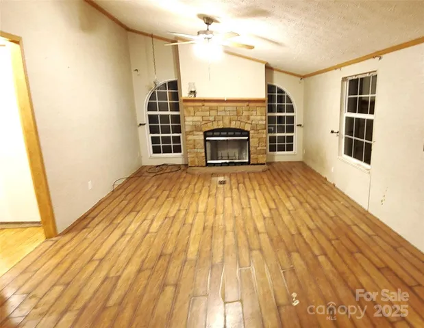 a view of a livingroom with wooden floor and a fireplace
