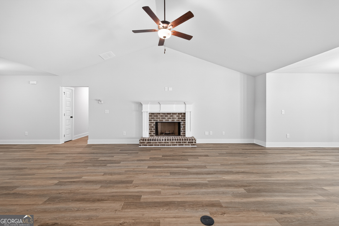 206 Airport Road, Unit 11 Canon, GA 30520 - Photo 8 of 34 a view of an empty room with wooden floor and a fireplace