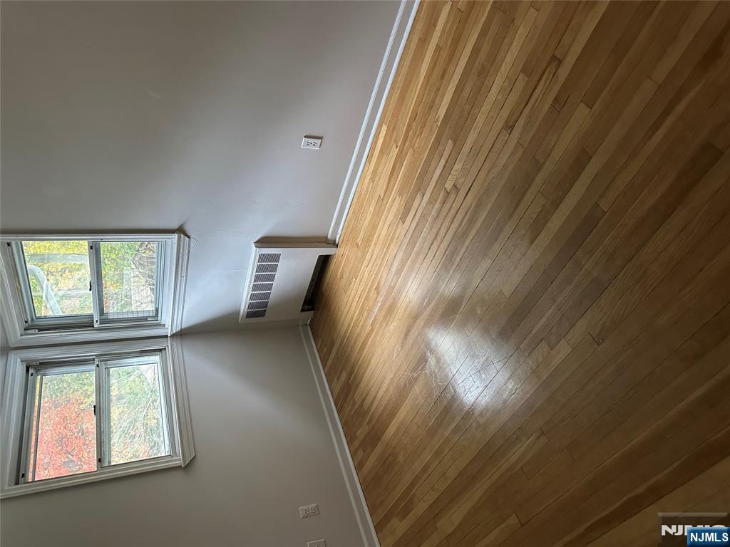 743 Newcomb Road Ridgewood, NJ 07450 - Photo 5 of 16 a view of an empty room with wooden floor and a window