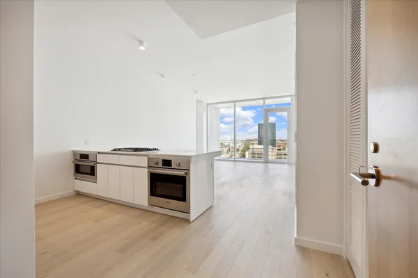 a view of a kitchen with a stove wooden floor and a window
