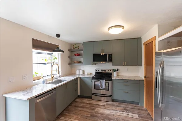 a kitchen with stainless steel appliances granite countertop a sink stove and refrigerator