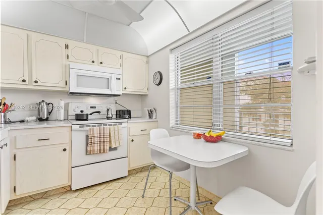 a kitchen with stainless steel appliances white cabinets and a window