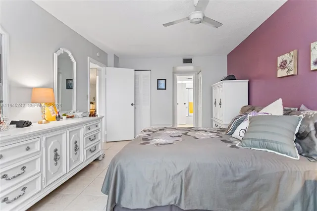 a bedroom with a bed a chandelier and dresser