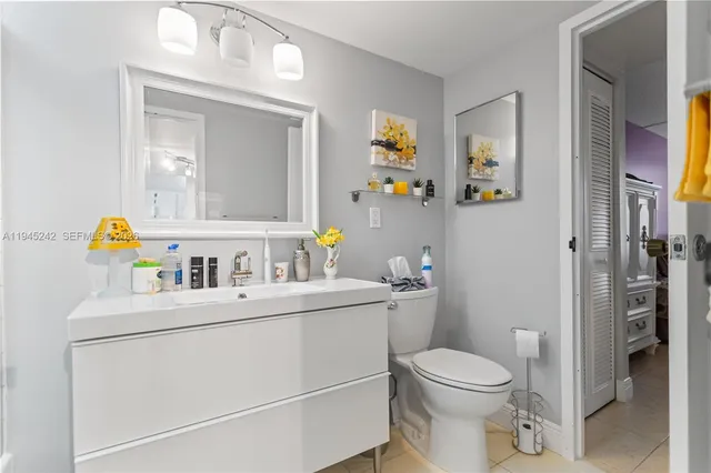 a bathroom with a sink vanity mirror and toilet