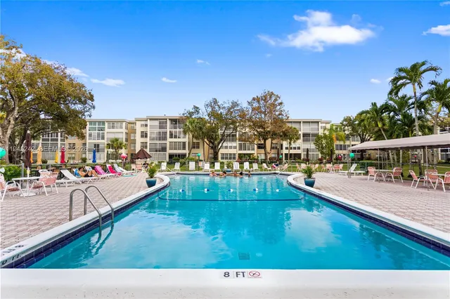 a view of a swimming pool with a patio and dining space