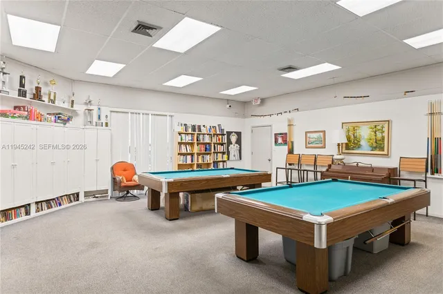 a room with pool table and windows