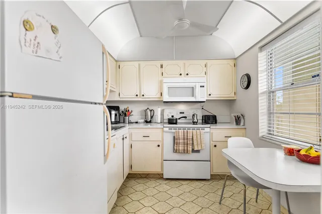 a kitchen with stainless steel appliances a refrigerator sink and white cabinets