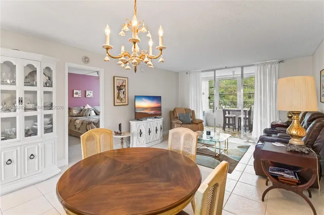 a living room with furniture a chandelier and a dining table