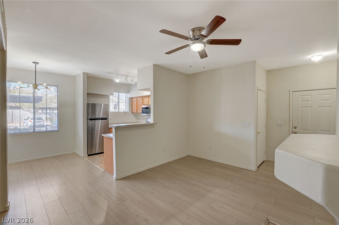 9050 West Warm Springs Road, Unit 1147 Las Vegas, NV 89148 - Photo 3 of 36 The open-concept layout features light-toned flooring and a convenient breakfast bar.