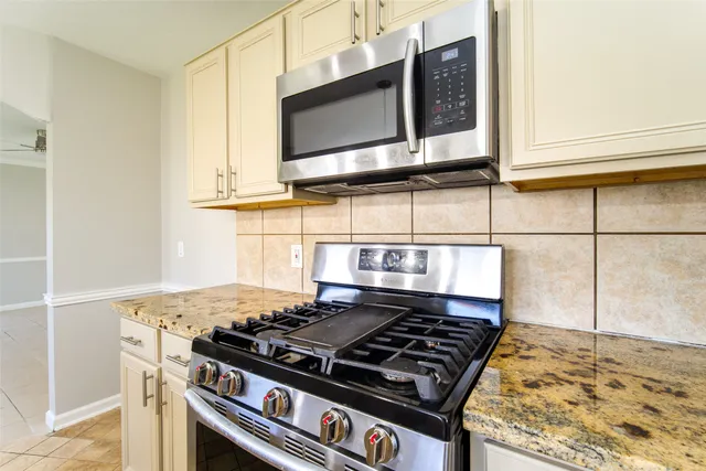 a stove top oven sitting inside of a kitchen