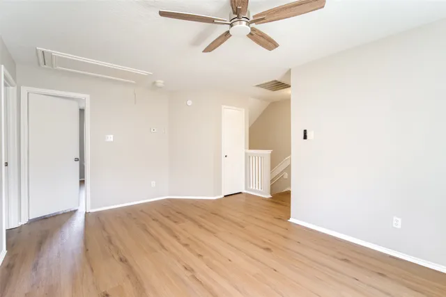 a view of empty room with wooden floor