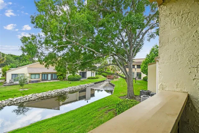 a kitchen with stainless steel appliances granite countertop wooden cabinets a refrigerator a stove a sink and a dining table with wooden floor