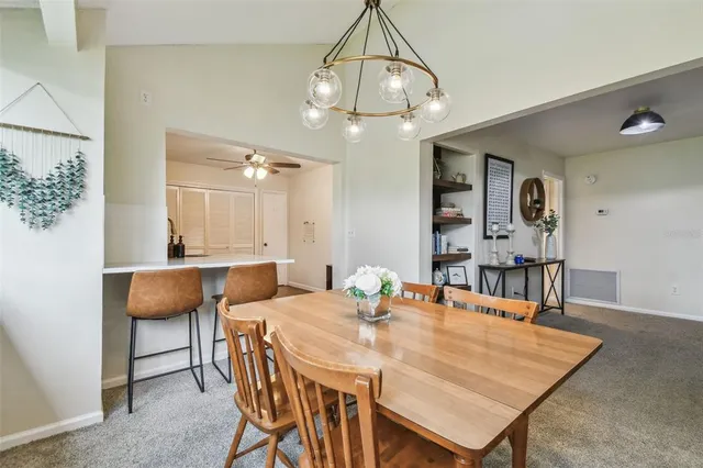 a kitchen with a sink a refrigerator and chairs