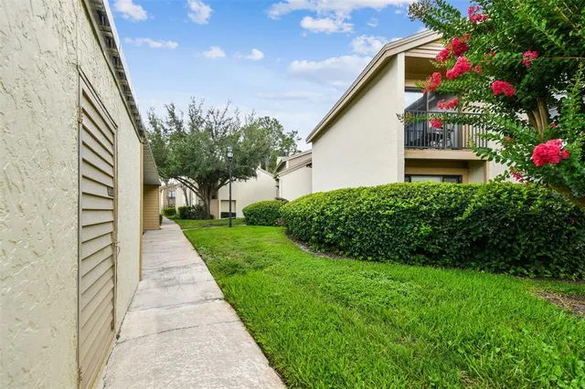 a balcony with table and chairs potted plants