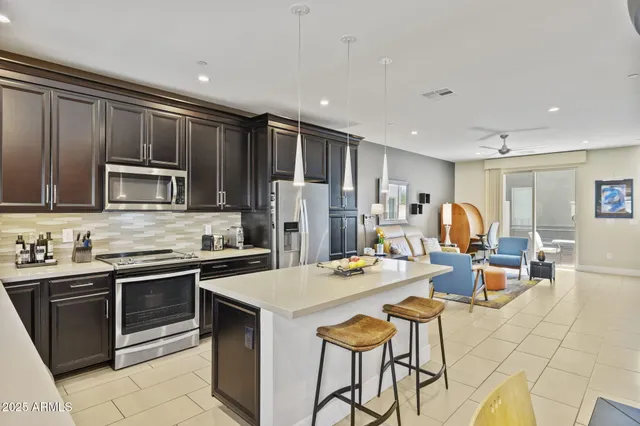 a kitchen with a sink stove and chairs