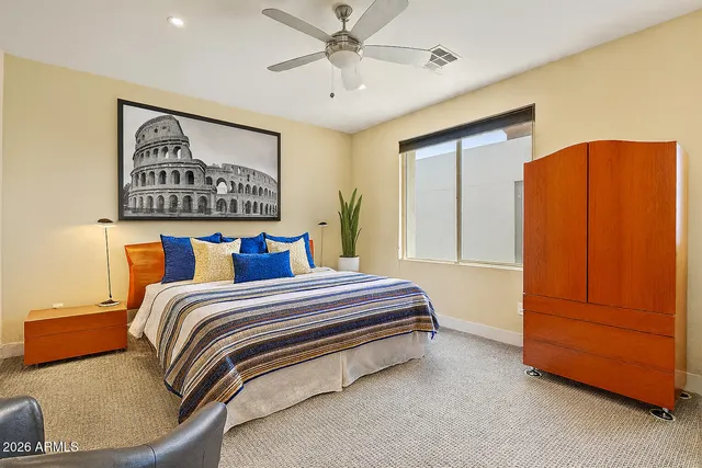 a spacious bedroom with a bed and cabinet