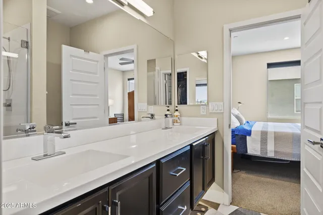 a en suite bathroom with a double vanity sink and a mirror