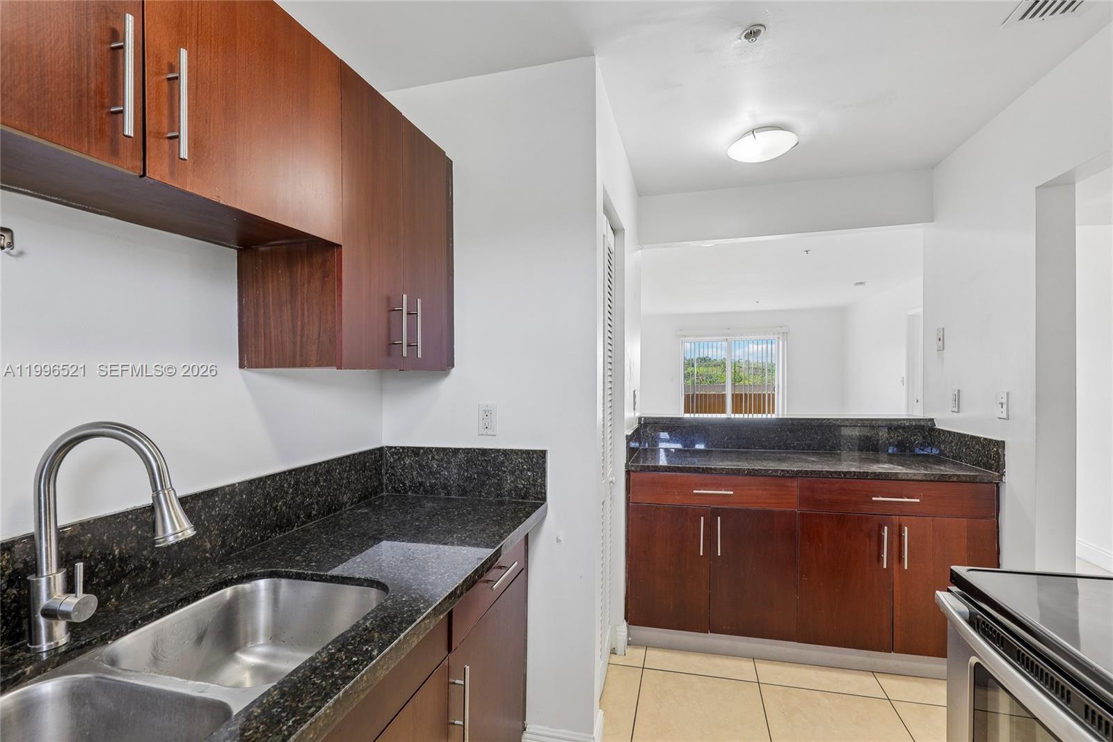 4137 Stirling Road, Unit 507 Dania Beach, FL 33314 - Photo 6 of 20 a kitchen with granite countertop a stove sink and cabinets
