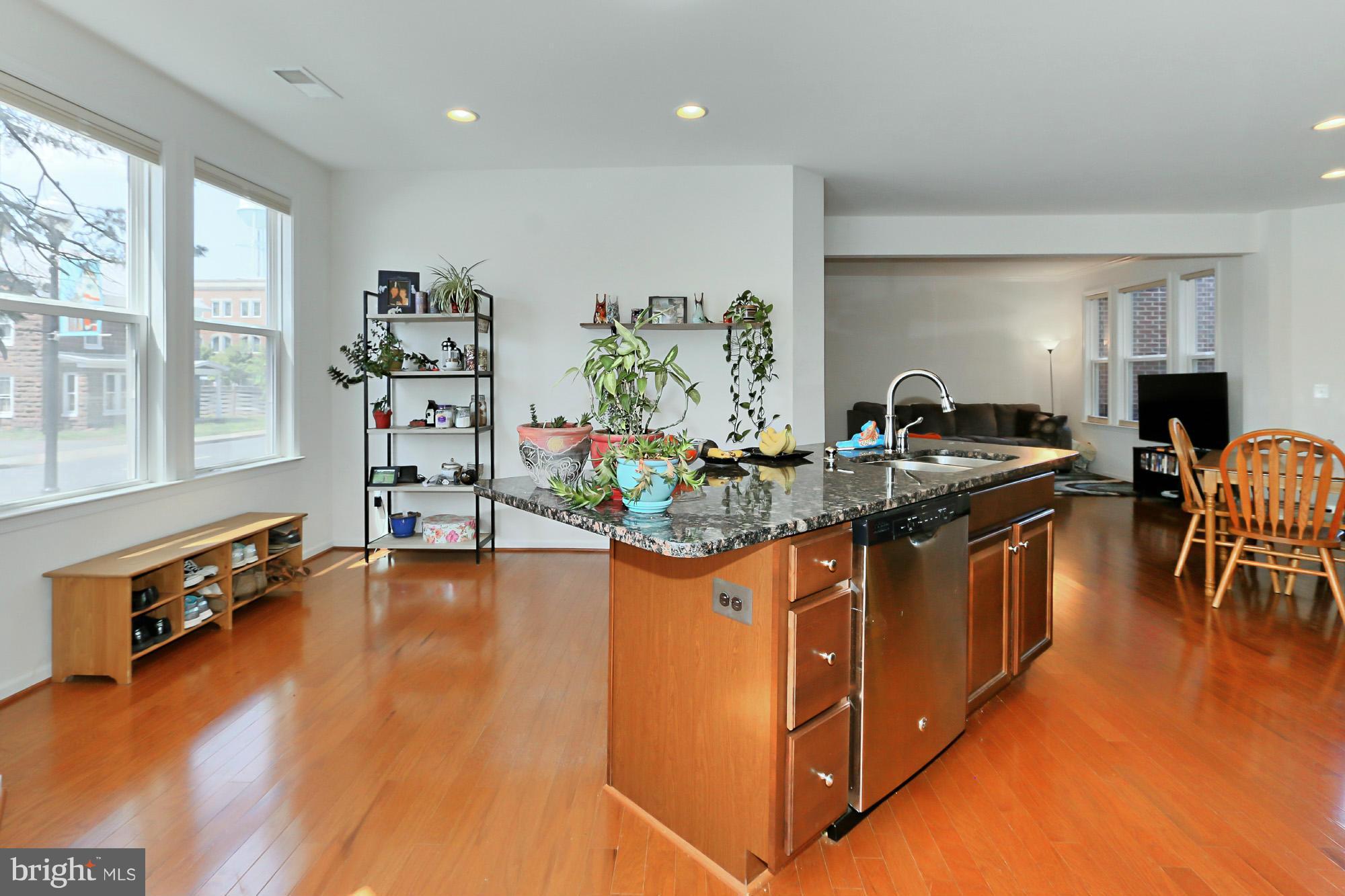 9419 Zebedee Street Manassas, VA 20110 - Photo 11 of 30 a kitchen with stainless steel appliances granite countertop a stove and a living room