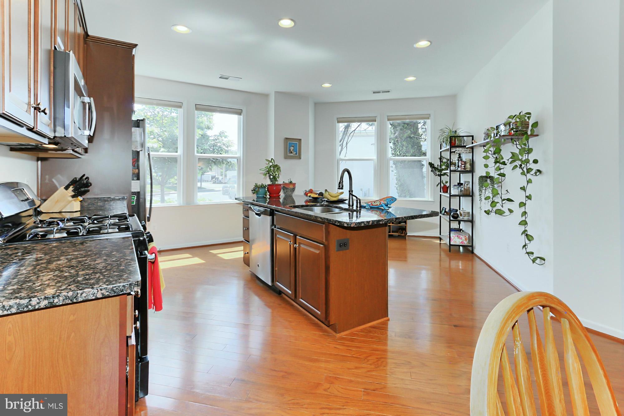 9419 Zebedee Street Manassas, VA 20110 - Photo 12 of 30 a kitchen with stainless steel appliances granite countertop a stove and a wooden floors