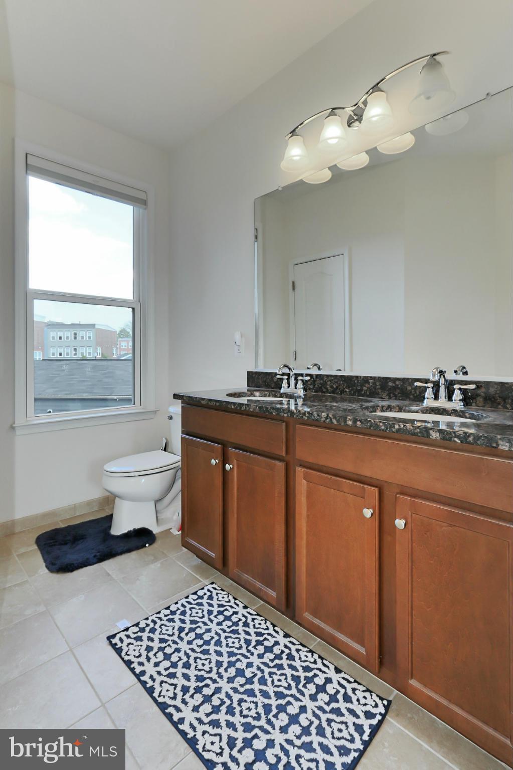 9419 Zebedee Street Manassas, VA 20110 - Photo 20 of 30 a spacious bathroom with a granite countertop sink a mirror and a toilet
