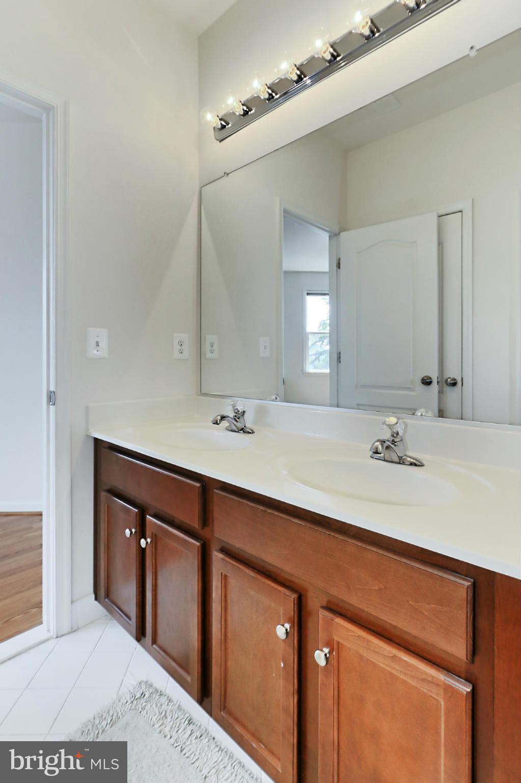 9419 Zebedee Street Manassas, VA 20110 - Photo 25 of 30 a bathroom with a double vanity sink and a mirror