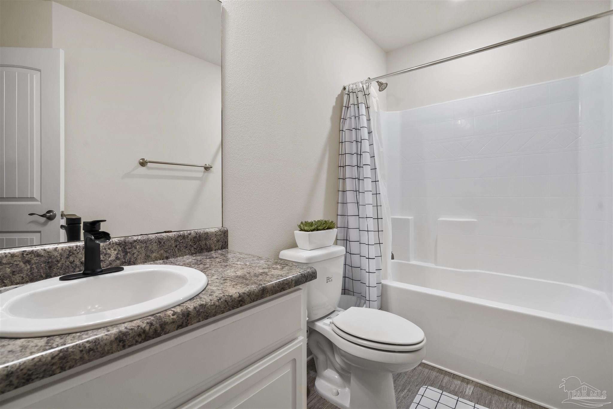 151 Cottage View Drive Pensacola, FL 32507 - Photo 14 of 17 a bathroom with a granite countertop toilet a sink and a bathtub