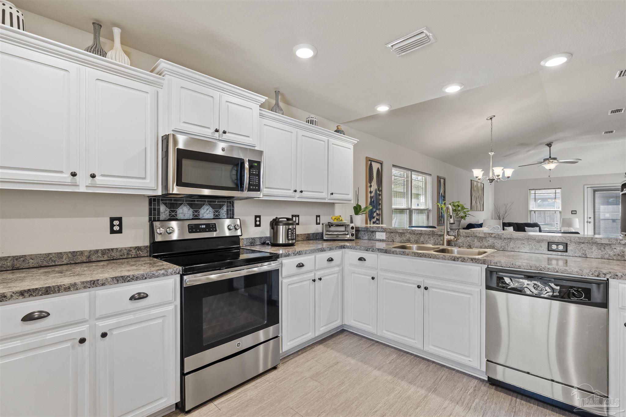151 Cottage View Drive Pensacola, FL 32507 - Photo 4 of 17 a kitchen with appliances a sink and cabinets