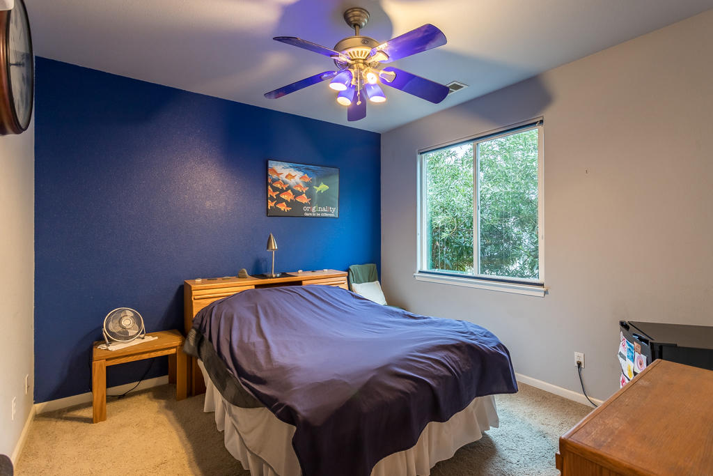 1575 Barbara Road Redding, CA 96003 - Photo 18 of 27 a bedroom with a bed and a chandelier