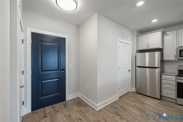 a view of empty room with wooden floor