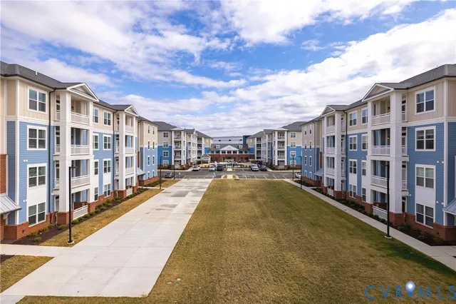 a view of residential houses with cars parked