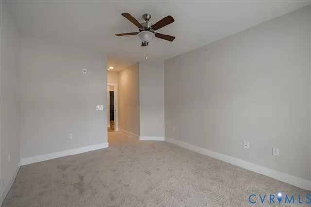 an empty room with closet and a chandelier fan