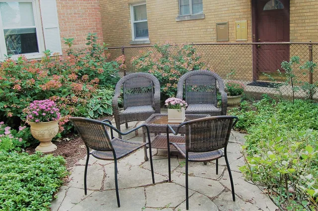 a view of a chairs and table in backyard of the house