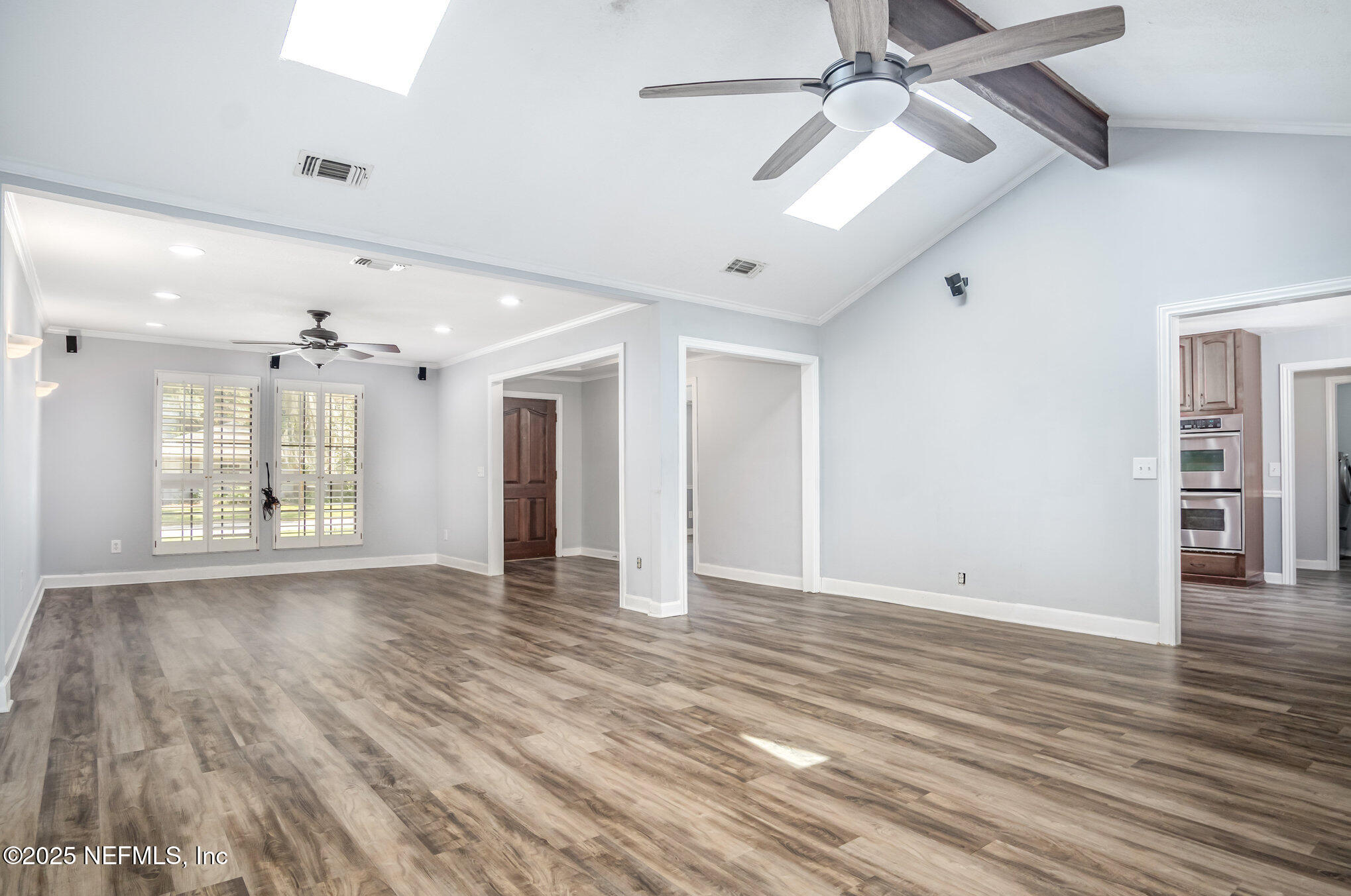 12046 Acornshell Way Jacksonville, FL 32223 - Photo 11 of 28 a view of an empty room with wooden floor and a ceiling fan