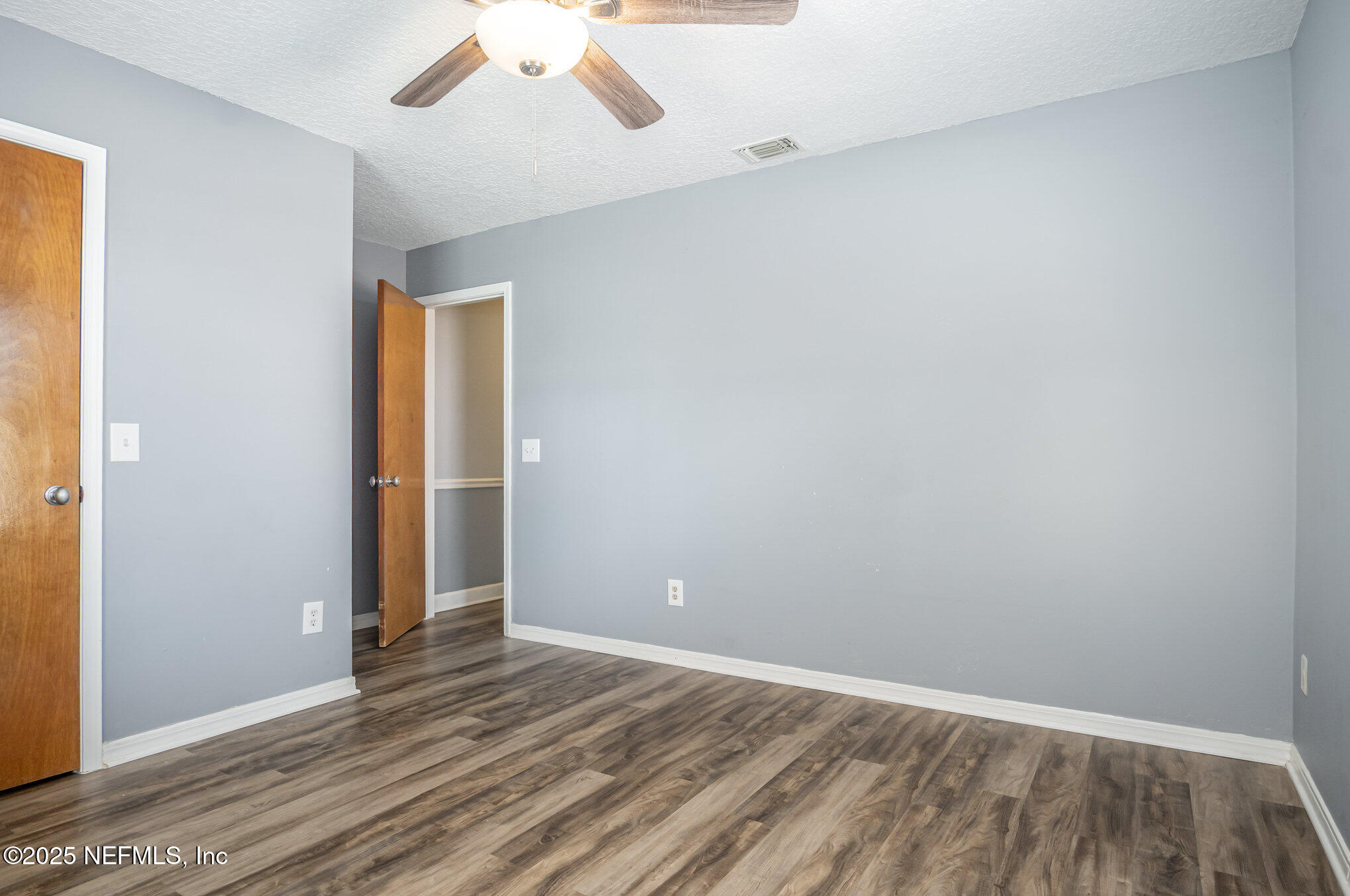 12046 Acornshell Way Jacksonville, FL 32223 - Photo 21 of 28 an empty room with wooden floor and windows