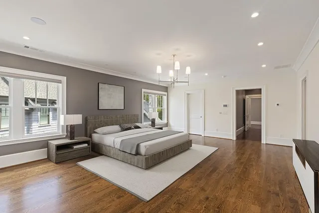 a spacious bedroom with a large bed and a chandelier
