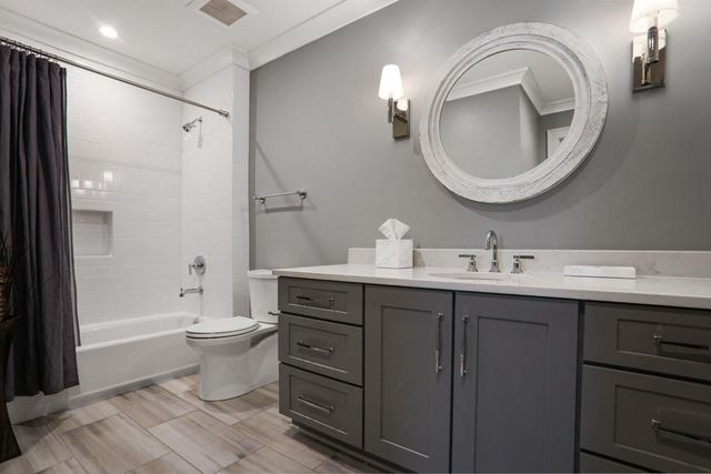 a bathroom with a toilet sink double vanity and mirror
