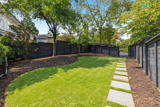 a front view of a house with a yard and wooden fence
