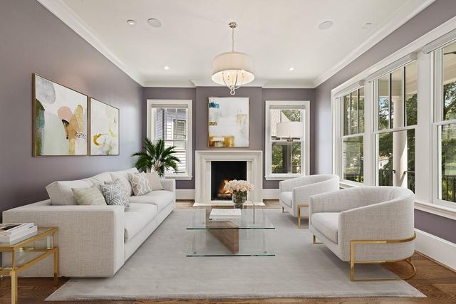 a living room with furniture fireplace and large windows