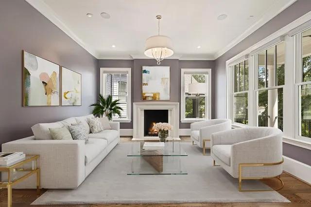 a living room with furniture fireplace and large windows