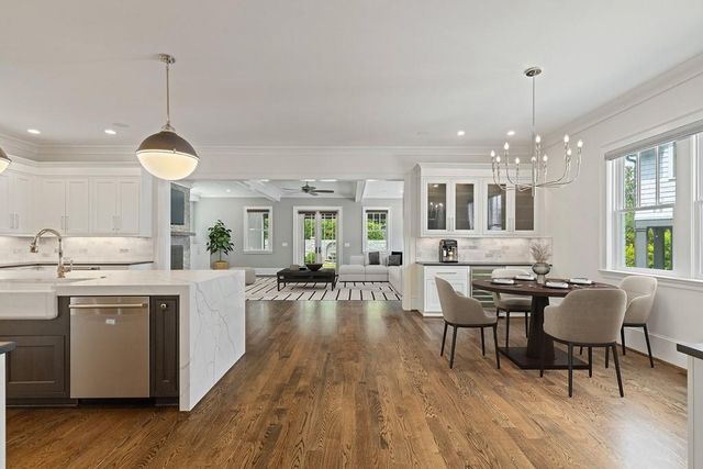 a dining room with furniture a chandelier and wooden floor