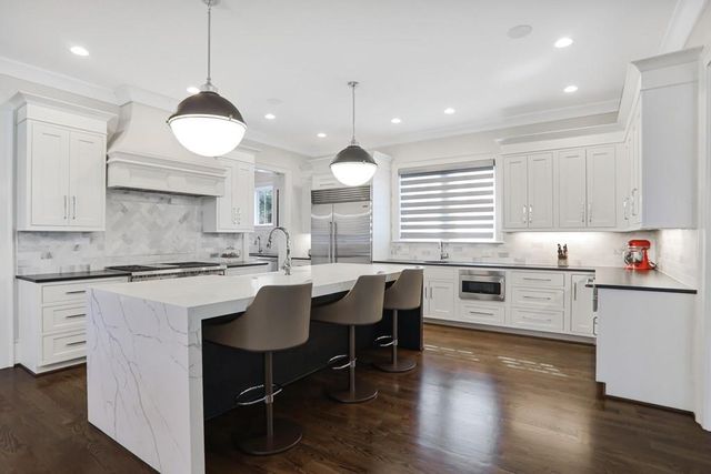 a kitchen with a dining table chairs sink and cabinets