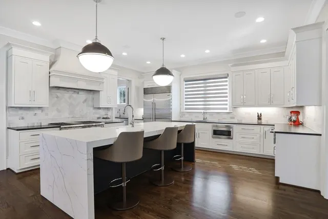 a kitchen with a dining table chairs sink and cabinets