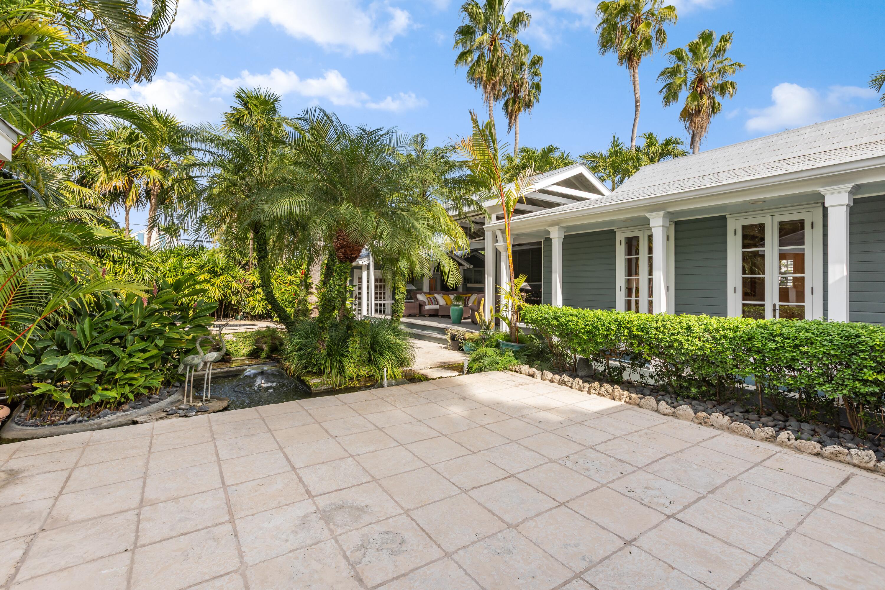 910-914 Watson Street Key West, FL 33040 - Photo 26 of 38 a view of a white house with a flower garden in front of it