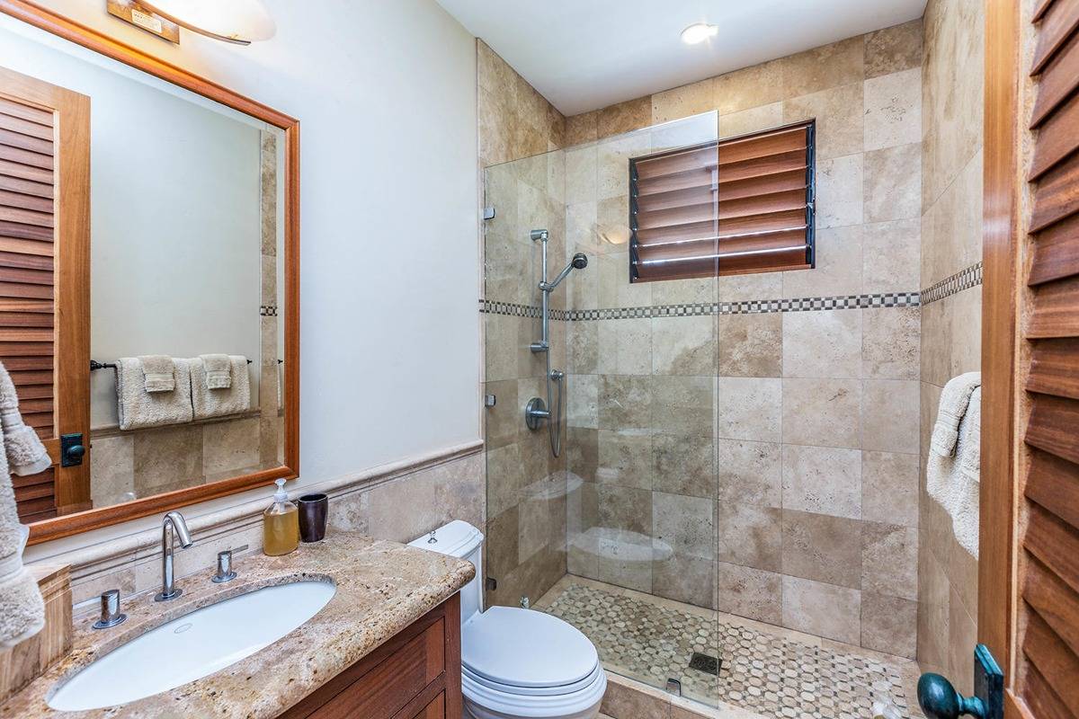 5070 Kukuna Road Kilauea, HI 96754 - Photo 21 of 30 a bathroom with a granite countertop sink toilet a mirror and shower