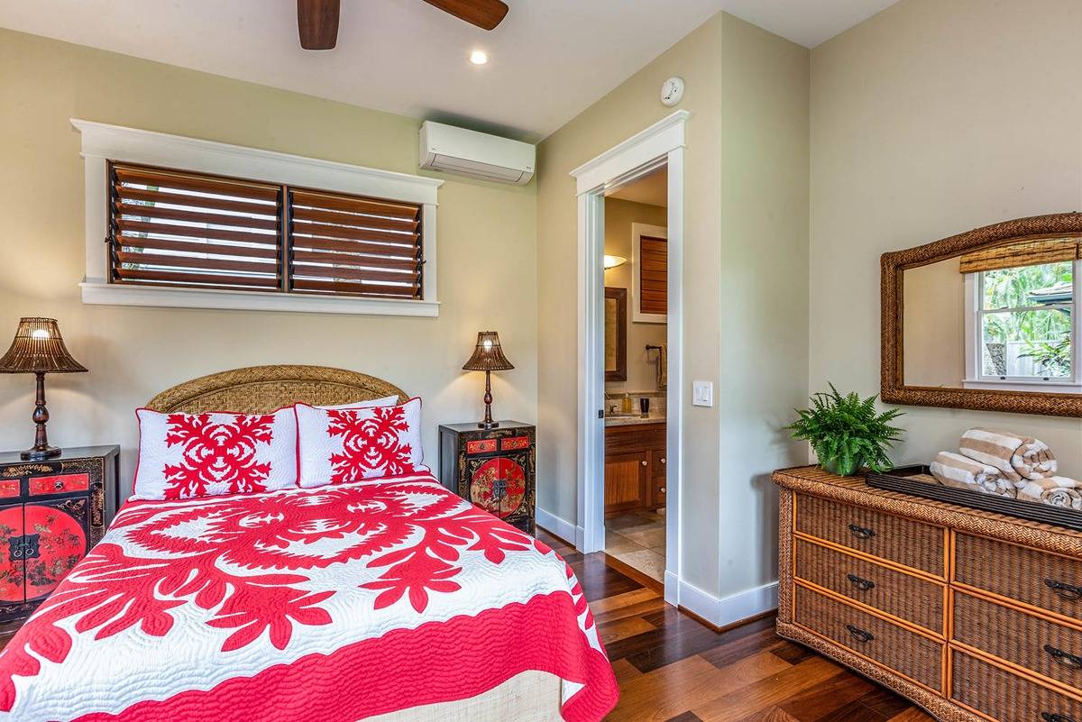 5070 Kukuna Road Kilauea, HI 96754 - Photo 23 of 30 a bedroom with a bed and wooden floor