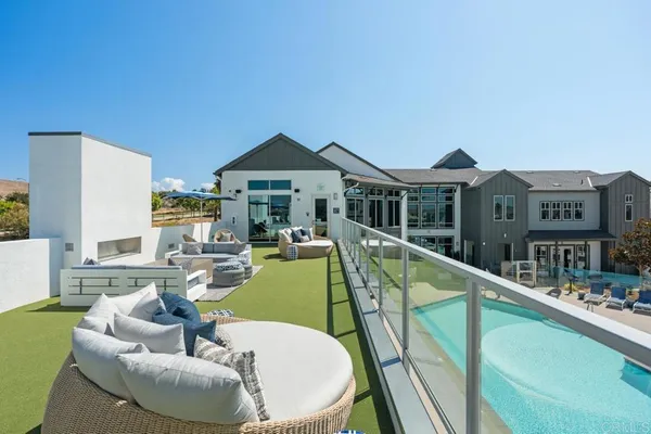 a view of swimming pool with outdoor seating and house in the background