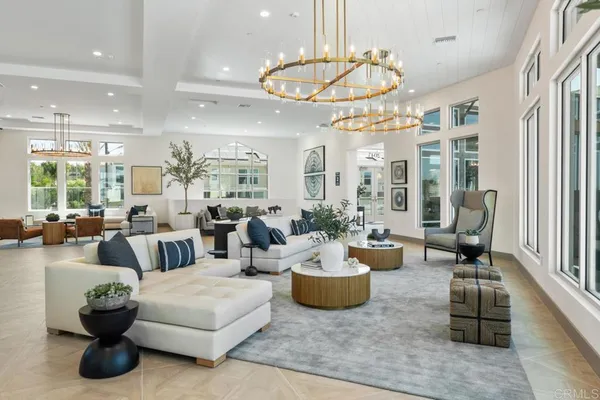 a living room with furniture a chandelier and a dining table